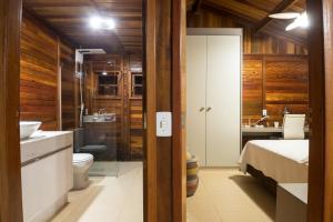 韦尔卡鲍Casinha de Madeira no Vale do Capão的一间带床、水槽和卫生间的浴室