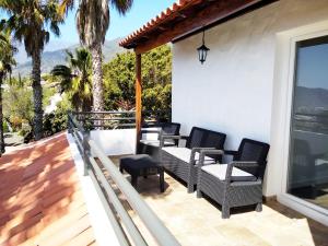埃尔帕索Villa Bellavista的一个带椅子的庭院和一个棕榈树阳台