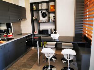 波尔蒂芒Apartamento Jeni Residencia Flamingo的厨房配有黑桌和凳子