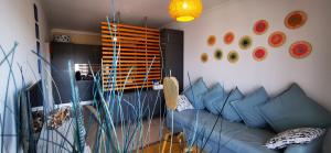 波尔蒂芒Apartamento Jeni Residencia Flamingo的客厅配有蓝色的沙发和墙上的盘子