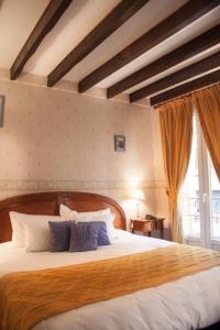 图卢兹Hôtel Riquet的一间卧室配有一张带蓝色枕头的大床