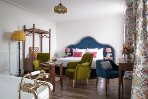 圣埃斯泰夫La Maison d'Estournel的一间卧室配有一张带绿色椅子的床和一张桌子