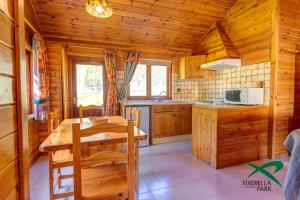 希塞雷拉希瑟雷拉公园简易别墅露营地的小屋内的厨房配有木制橱柜和桌子
