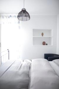 伊佐拉Little house - Hiška的白色卧室配有床和椅子