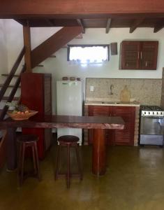 莫罗圣保罗Vila Sofia chalès的厨房配有一张大木桌和凳子