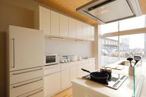 Motoshin渚泊魚津丸的厨房配有白色橱柜和台面