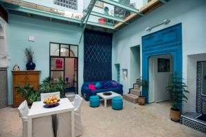 非斯Dar anne的客厅拥有蓝色的墙壁和蓝色的沙发