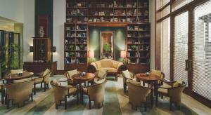 雅加达达哈旺萨雅加达酒店的一间设有桌椅的餐厅,位于带架子的房间