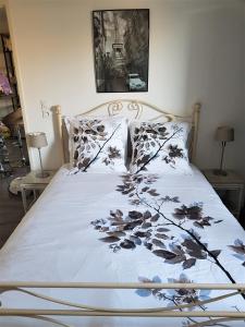 阿维尼翁APPARTEMENT T2 AGROPARC AVIGNON的一张带白色棉被和鲜花的床