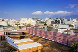 雅典Central Stay Athens的阳台设有桌子,享有城市美景。
