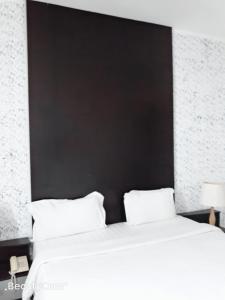 斯里巴加湾市昆普勒克吉拿27号酒店的一间卧室配有一张大床和黑色床头板
