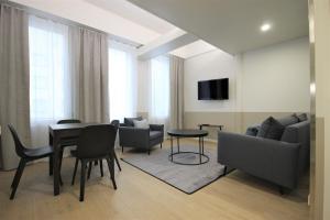 瓦尔考斯Forenom Aparthotel Varkaus的客厅配有桌椅和沙发