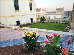 圣凯撒利亚温泉Villa Cesarea Dimora di Charme的一座花园,在一座建筑前种有鲜花