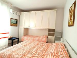 阿尔盖罗La Mandronia B&B的卧室设有2张床和白色橱柜。