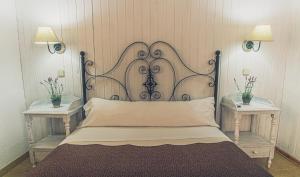 米拉弗洛迪拉希穆涅吉亚酒店的一张带金属床头板的床,位于带两张桌子的房间