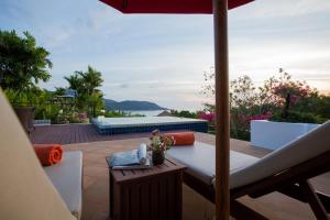 卡塔海滩Ocean views Kata gardens penthouse 6C的享有带桌子和遮阳伞的庭院的景色。