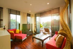 卡塔海滩Ocean views Kata gardens penthouse 6C的客厅配有红色椅子和电视