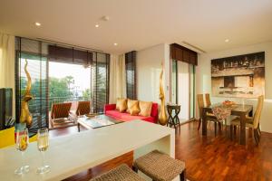 卡塔海滩Ocean views Kata gardens penthouse 6C的客厅配有红色的沙发和桌子