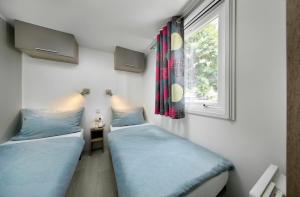 巴特迪克海姆KNAUS Campingpark Bad Dürkheim的带窗户的客房内的两张床