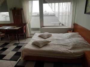 科沃布热格埃特纳波尼亚公寓的一间卧室配有一张床、一张桌子和一个窗户。