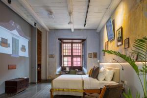 科钦The Postcard Mandalay Hall, Kochi的一间卧室设有一张大床和一个窗户。