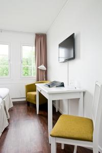AlftaGästisbacken的客房设有书桌、椅子和桌子。