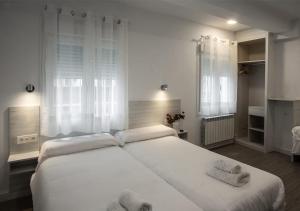 布尔戈斯拉尔旅馆 的卧室配有带毛巾的大型白色床