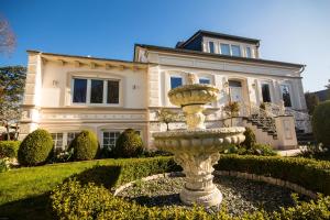 费马恩Villa Rosengarten的一座大房子前面有一个喷泉