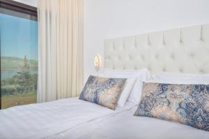 基内雷特פרימור סוויטות יוקרה Primor Deluxe Suits的卧室配有白色的床和大窗户
