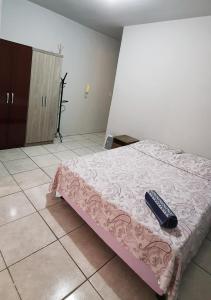 CachoeirinhaApto Jk em Cachoeirinha的一间卧室配有一张带遥控器的床