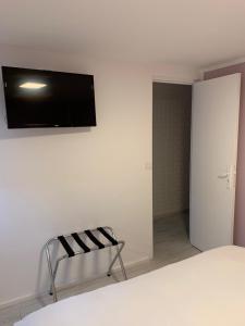 普罗旺斯艾克斯艾克斯酒店的卧室设有壁挂式电视和椅子