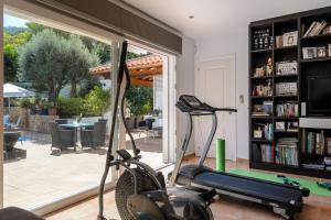 圣埃乌拉利亚Villa Blanca Santa Eulalia的一间设有跑步机和书架的健身房的客房