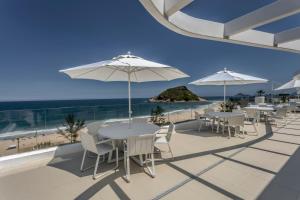 里约热内卢CDesign Hotel的海滩上一排桌椅和遮阳伞
