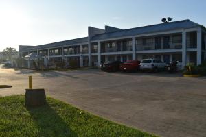 查尔斯湖Motel 6 Lake Charles, LA的停车场内停放汽车的大型建筑