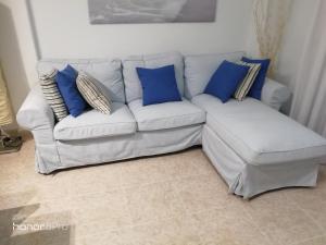 Caleta de InteriánThe terrace on the sea的客厅配有带蓝色枕头的白色沙发