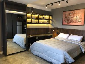 库里提巴Apartamento super bem decorado em frente ao shopping的一间卧室配有两张床、一张桌子和一面镜子