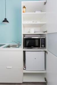 纽伦堡Studio Apartments nahe Messe的厨房配有带白色冰箱的微波炉