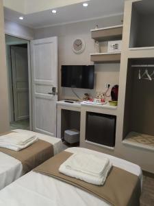 卡利亚里Guesthouse Luisella的客房设有两张床、一张桌子和一台电视机。