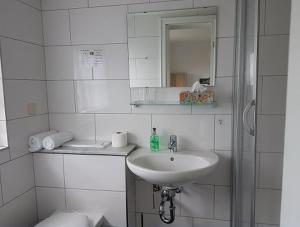 巴登-巴登温伯格餐厅酒店的白色的浴室设有水槽和镜子