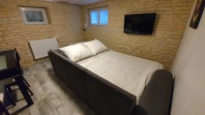 弗勒里莱欧布赖"LE TRAMWAY" Appartement 150m gare des Aubrais的砖墙房间的一个床位