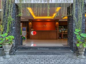 登巴萨Grand Mirah Boutique Hotel的商店前门,上面有红色标志