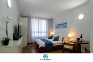 海法Almog Haifa Israel Apartments מגדלי חוף הכרמל的一间卧室配有一张床、一张桌子和一台电视