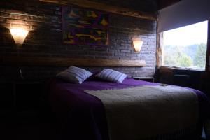 CholilaWau Purul的一间卧室设有一张床和砖墙