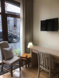 阿马Courtyard Mews Armagh City的客厅配有桌椅和电视。