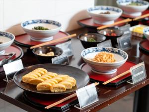 仓吉市Kurayoshi City Hotel的自助餐,桌上有碗食物