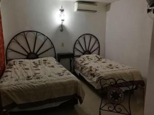 梅里达波萨达德尔天使酒店的两张睡床彼此相邻,位于一个房间里
