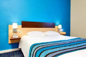 维里沙蒂隆基里亚德威利查狄龙酒店的一间卧室设有一张蓝色墙壁的大床