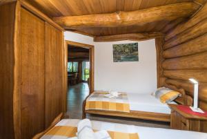 KopačevoBaranjska eko drvena kuća的木墙客房的两张床