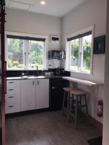 Wairau ValleyBirch Hill Cottage -30 minutes from St Arnaud的厨房配有白色橱柜、柜台和2扇窗户。