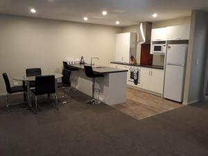 因弗卡吉尔South City Accommodation Unit 1的厨房配有桌椅和冰箱。